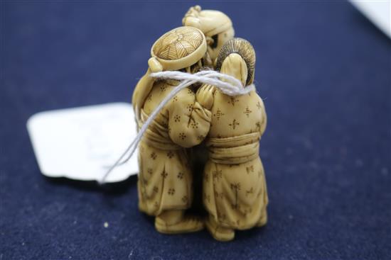 A Japanese ivory okimono carved with three figures height 6.5cm